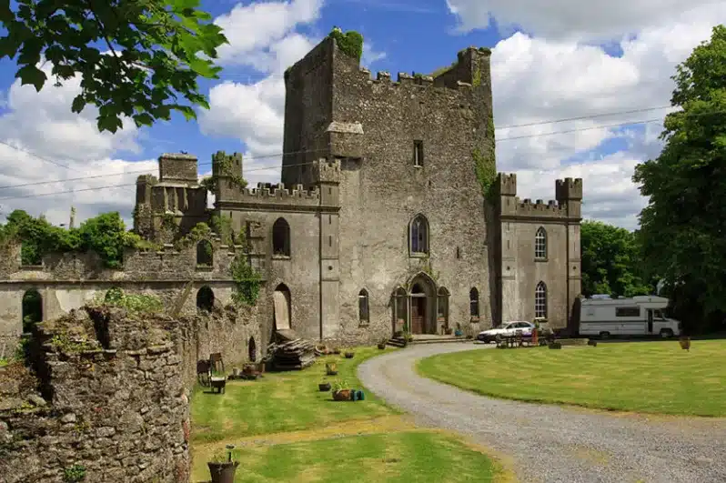 Medieval castle surrounded by greenery and a clear blue sky at Ardmore Country House.