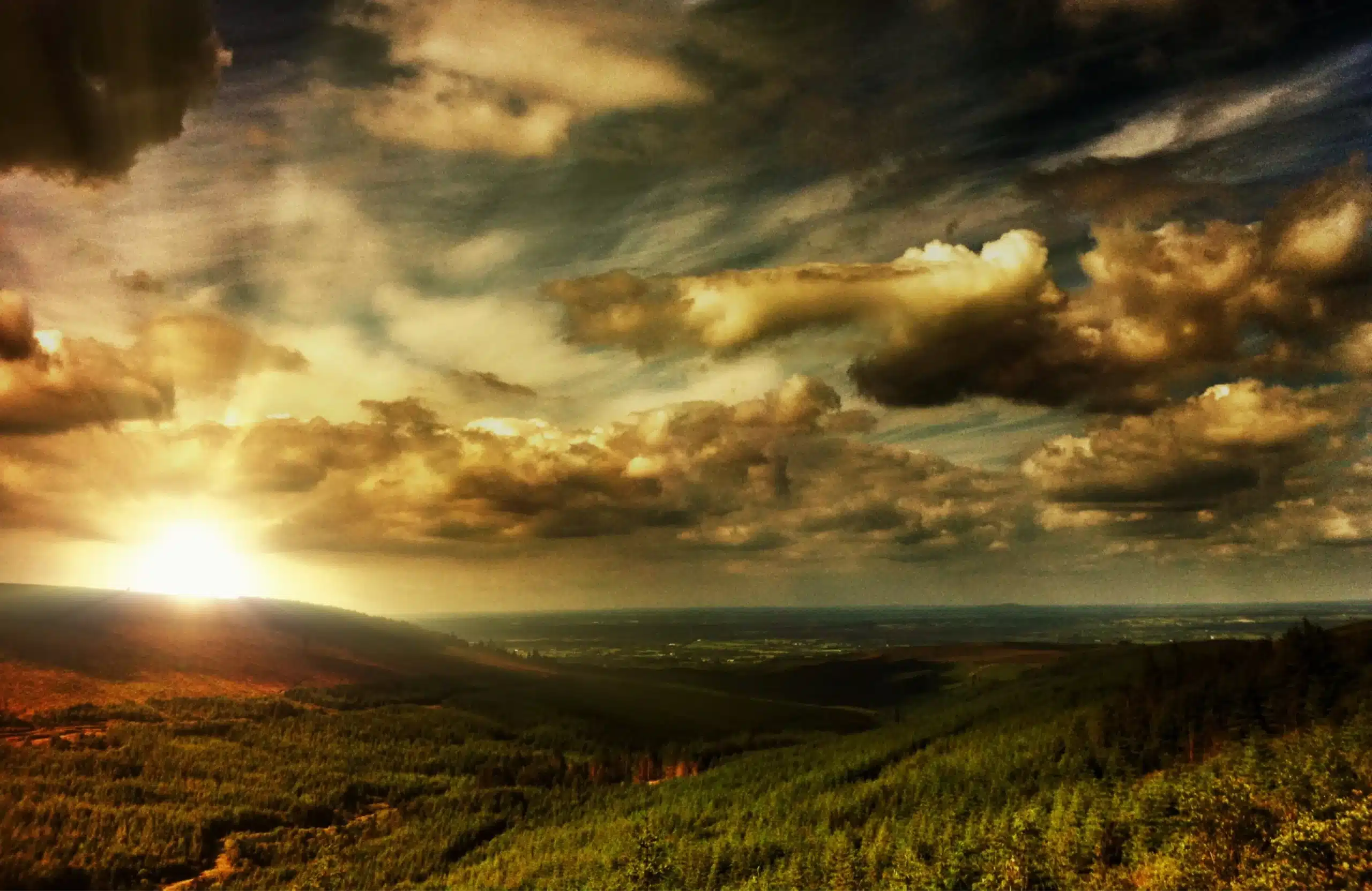 A breathtaking sunset illuminating the mountain valley with vibrant colors and dramatic clouds.
