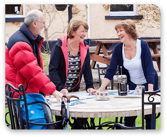 Friends enjoying drinks and conversation at a sunny outdoor table
