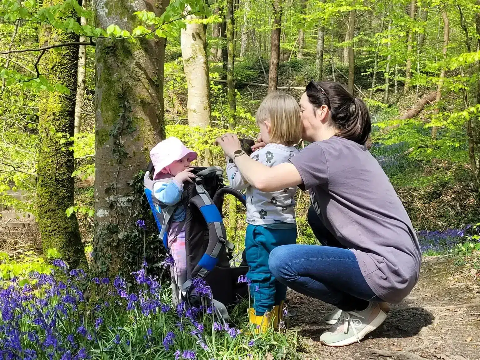 A mother and her children enjoying a hike through a lush green forest, surrounded by blooming flowers at Ardmore Country House